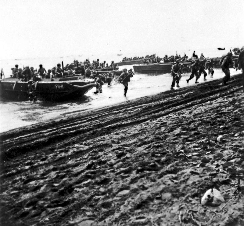 U.S. First Division Marines storm ashore across Guadalcanal's beaches on D-Day, 7 August 1942, from the attack transport USS Barnett (AP-11) and the attack cargo ship USS Fomalhaut (AK-22). The invaders were surprised at the lack of enemy opposition. (7 August 1942)