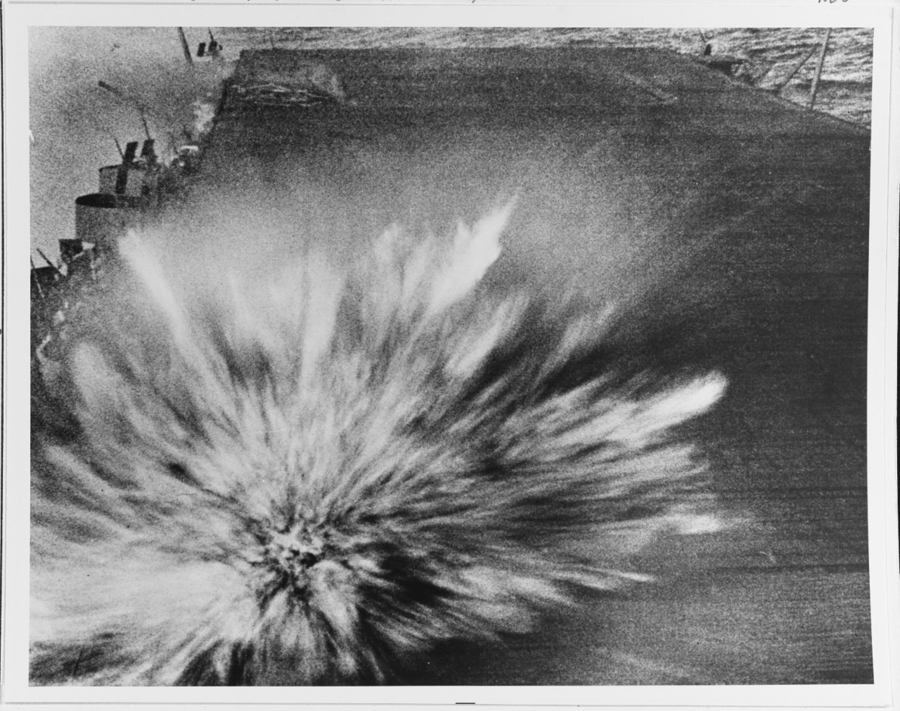 Battle of the Eastern Solomons, August 1942 A Japanese bomb exploding on the flight deck of USS Enterprise (CV-6), just aft of the island, on 24 August 1942. : According to the original photo caption, this explosion killed the photographer, Photographer's Mate 3rd Class Robert F. Read. However, Morison's History of U.S. Naval Operations in World War II (volume 5, page 97) states that Read was killed by the bomb that had earlier hit the after starboard 5/38 gun gallery, which can be seen burning in the upper left. Morison further states that the bomb seen here exploded with a low order detonation, inflicting only minor damage. Official U.S. Navy Photograph, now in the collections of the National Archives.