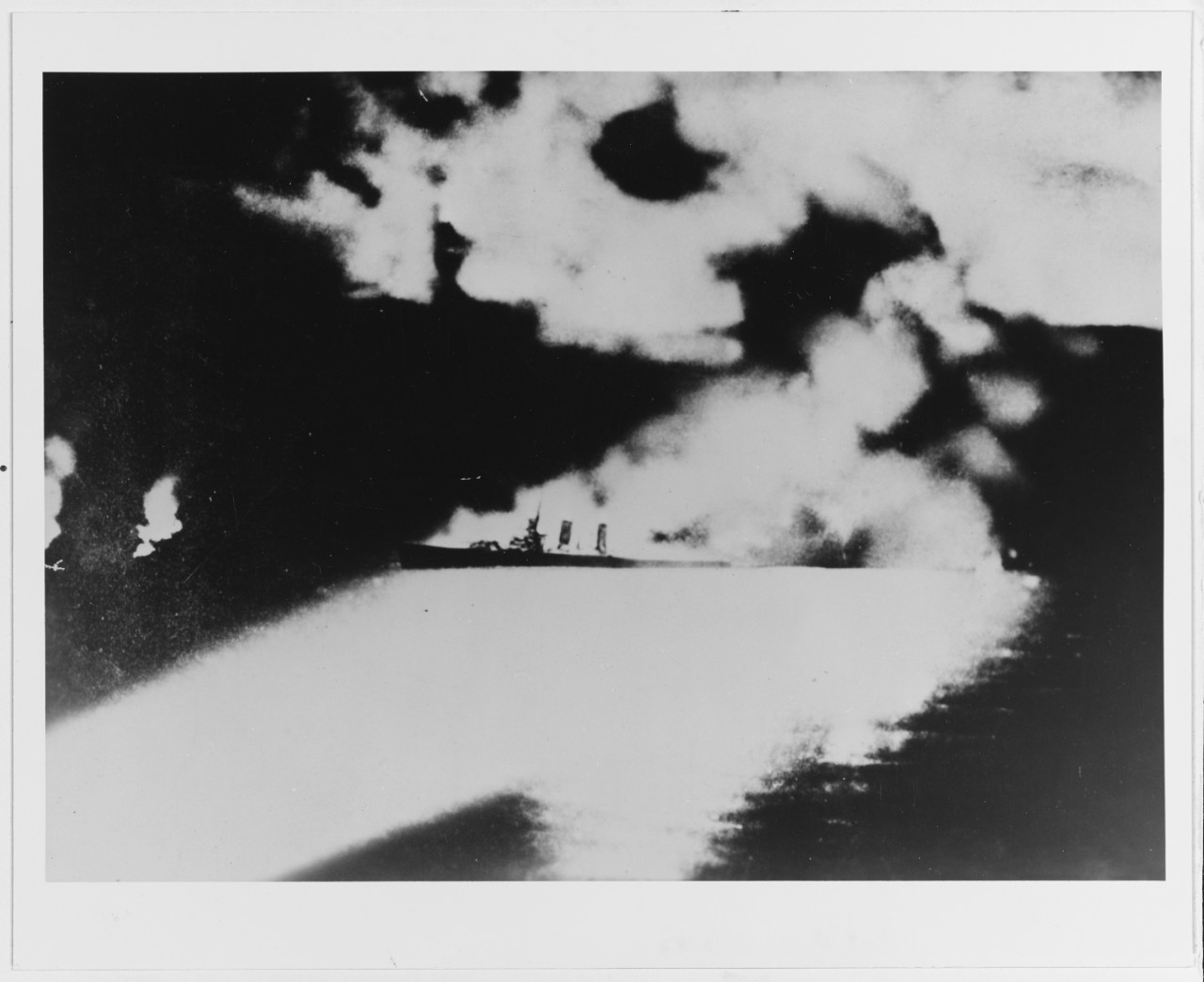 Photographed from a Japanese cruiser during the Battle of Savo Island, off Guadalcanal, 9 August 1942. Quincy, seen here burning and illuminated by Japanese searchlights, was sunk in this action. Copied from the Rear Admiral Samuel Eliot Morison World War II history illustrations file. U.S. Naval History and Heritage Command Photograph.